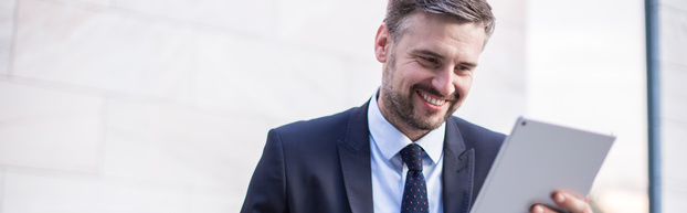 Happy businessperson looking at tablet's screen